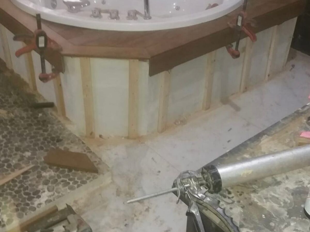 Bañera de hidromasaje en obra, con el revestimiento de madera a medio montar