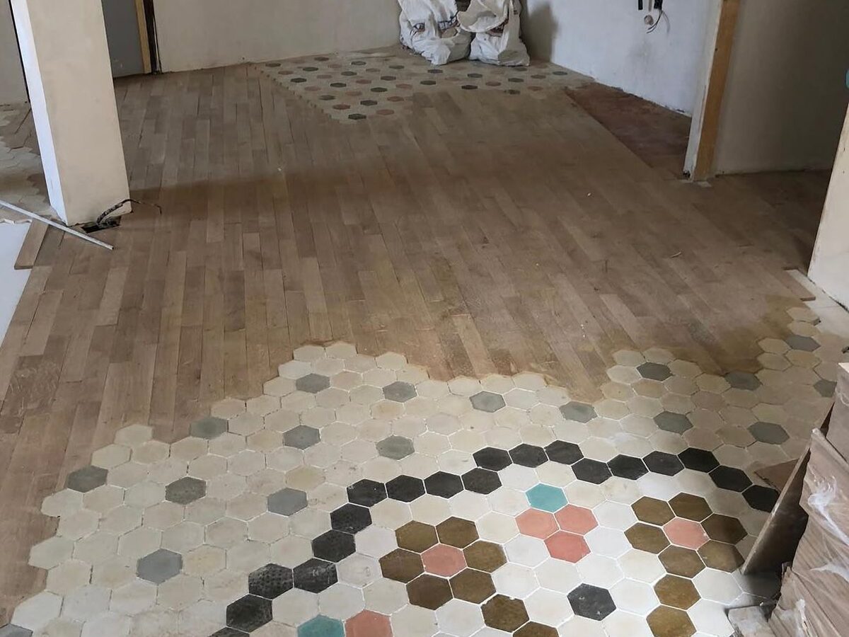 Suelo de madera instalado alrededor de la baldosa hidráulica original