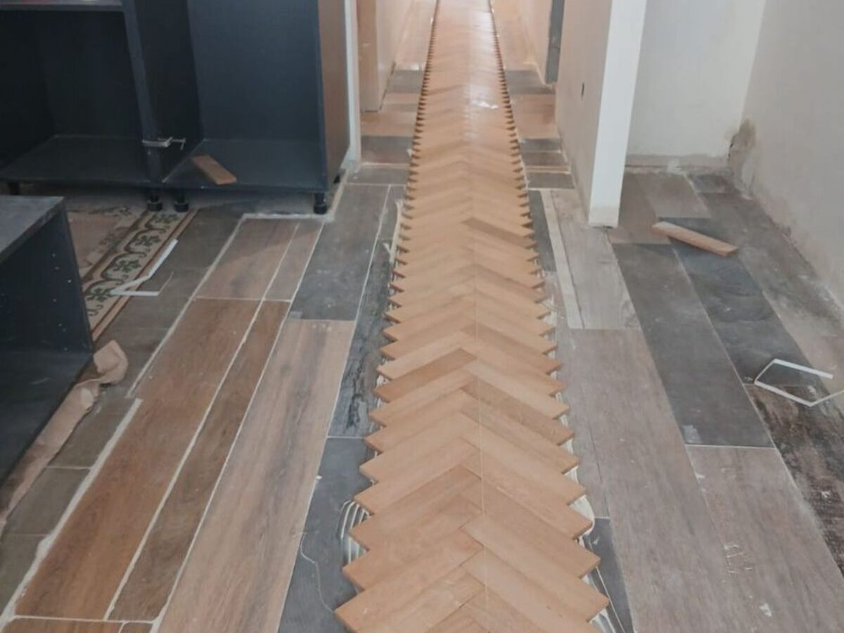 Faja de parquet en espiga terminada recorriendo el pasillo